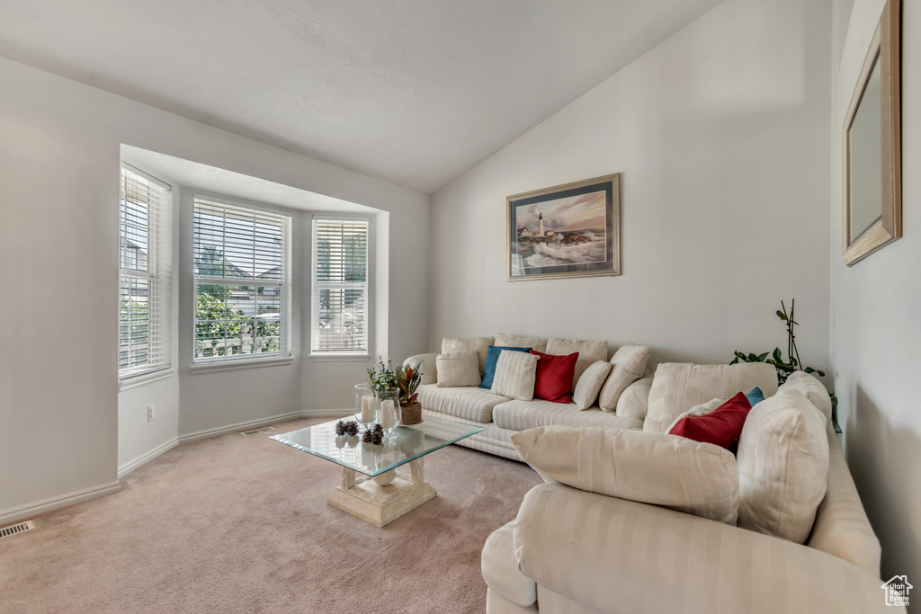 Living area featuring vaulted ceiling and carpet flooring