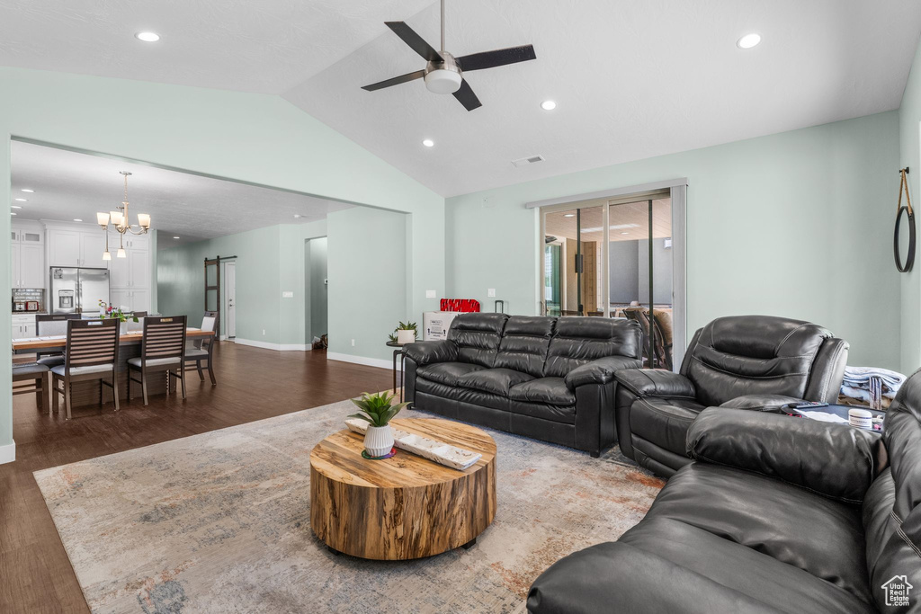 Living area with a ceiling fan, a chandelier, wood finished floors, recessed lighting, and vaulted ceiling