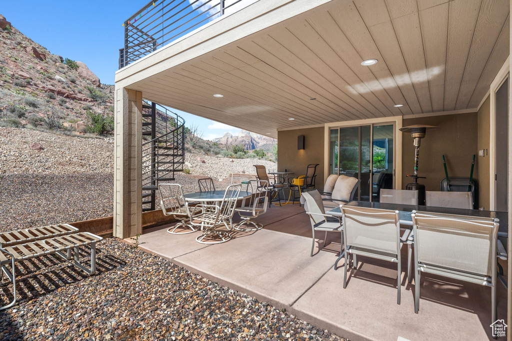 View of patio featuring a mountain view, outdoor dining space, and stairs