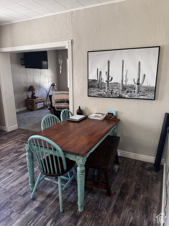Dining room featuring wood finished floors and a textured wall
