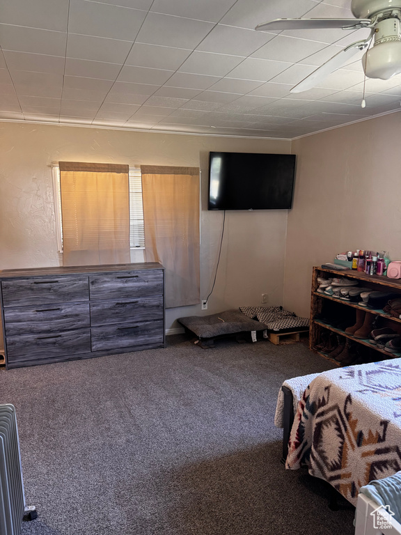 Carpeted bedroom with ceiling fan and ornamental molding