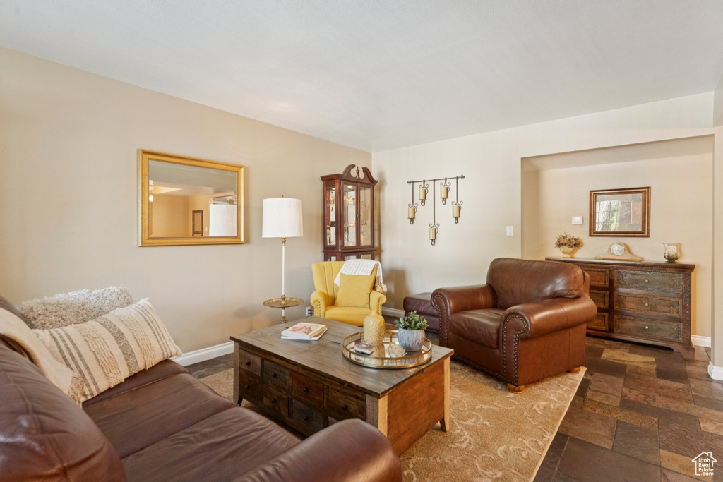 Living room with baseboards and stone finish floors