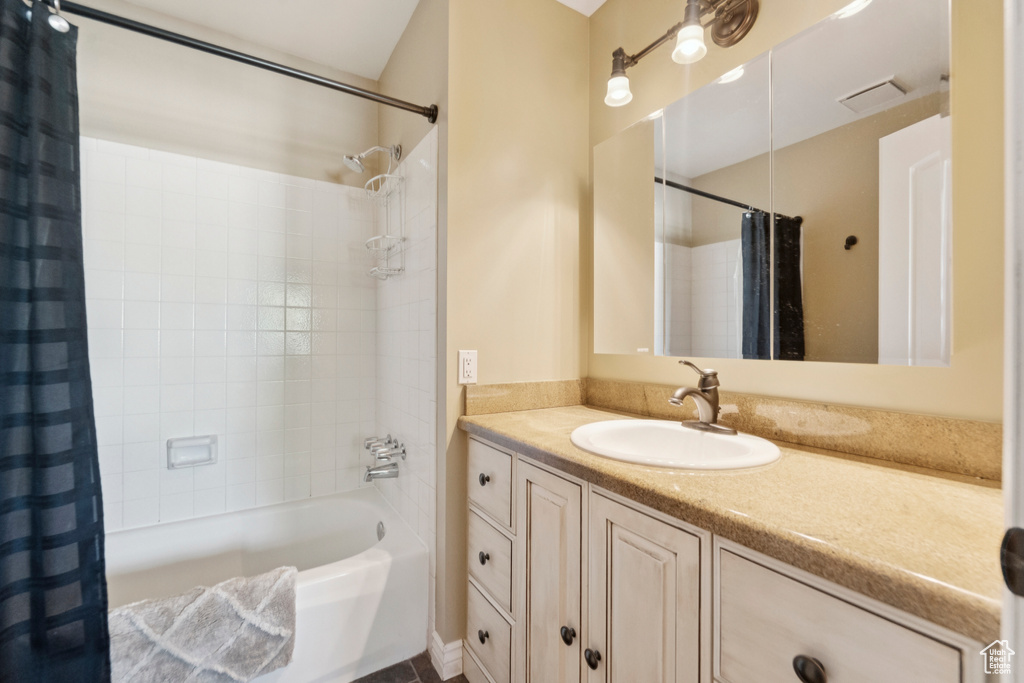 Bathroom featuring shower / tub combo with curtain and vanity