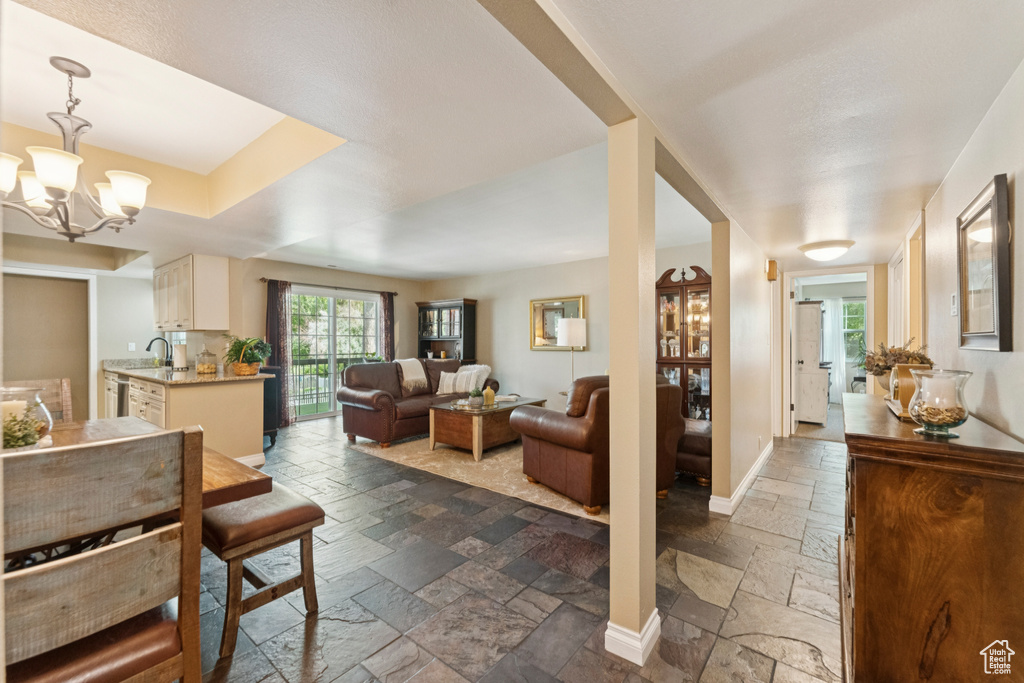 Dining area with stone tile flooring and a chandelier