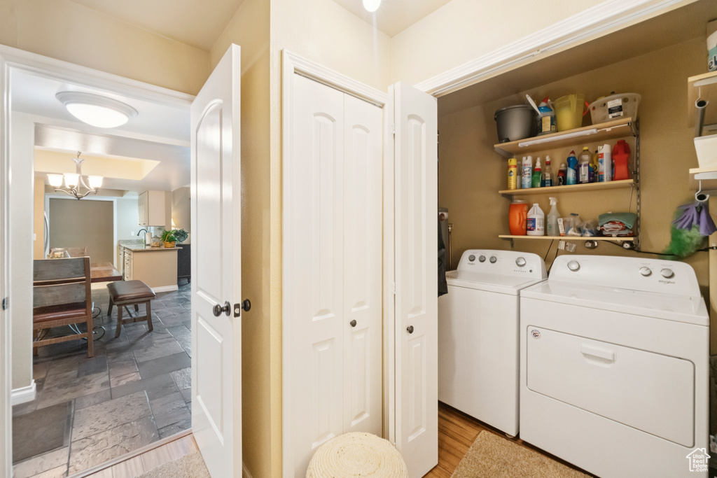 Laundry area with independent washer and dryer and a chandelier