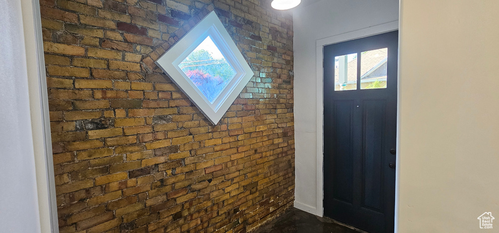 Entryway featuring brick wall