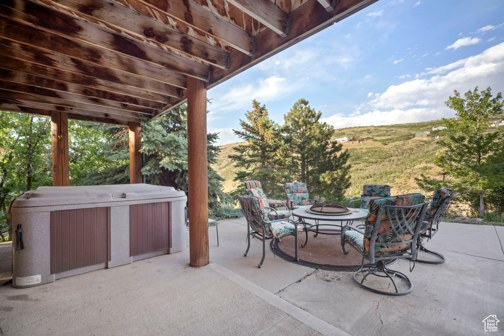 View of patio / terrace featuring a hot tub and an outdoor fire pit