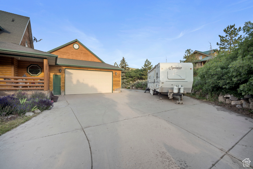 View of side of property with driveway and a garage