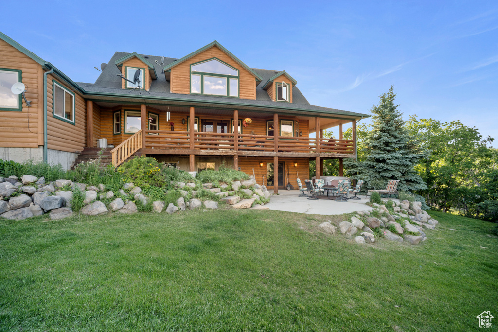 Rear view of property with a yard, a patio, and log exterior