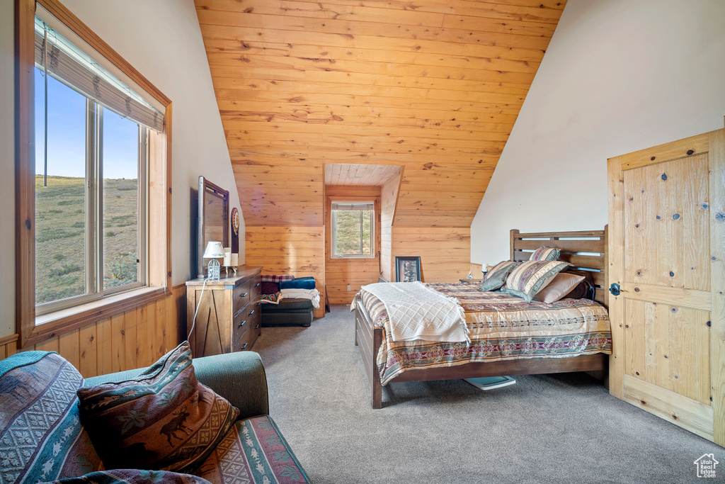 Bedroom featuring wooden walls, lofted ceiling, carpet flooring, and wooden ceiling