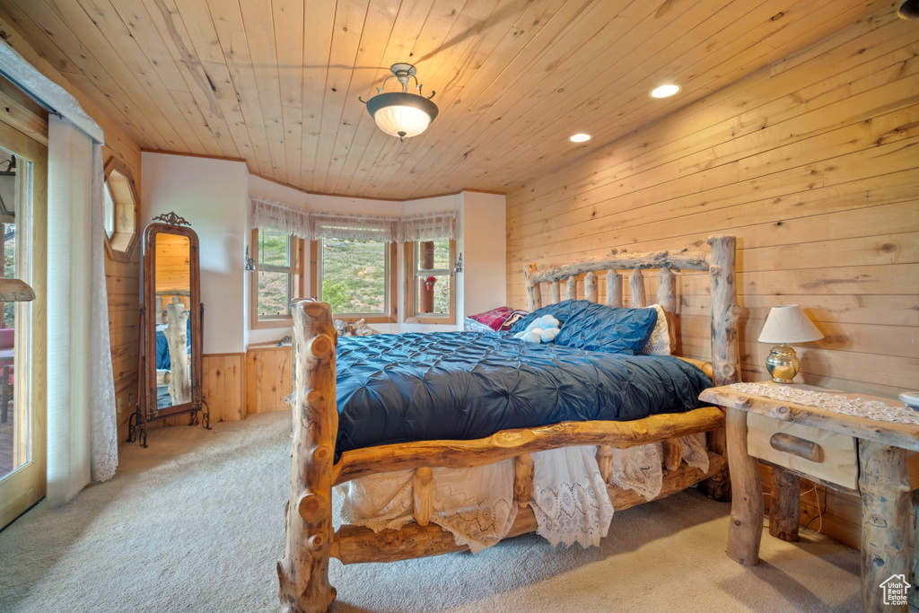 Carpeted bedroom featuring wood walls, wood ceiling, a wainscoted wall, and recessed lighting