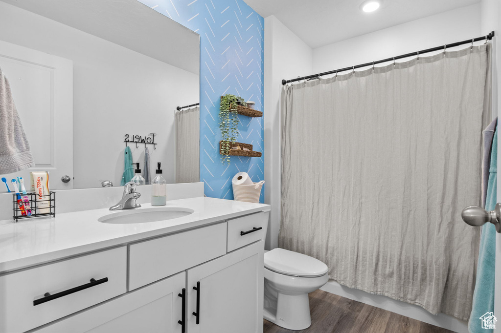 Full bath featuring vanity, wood finished floors, recessed lighting, and curtained shower