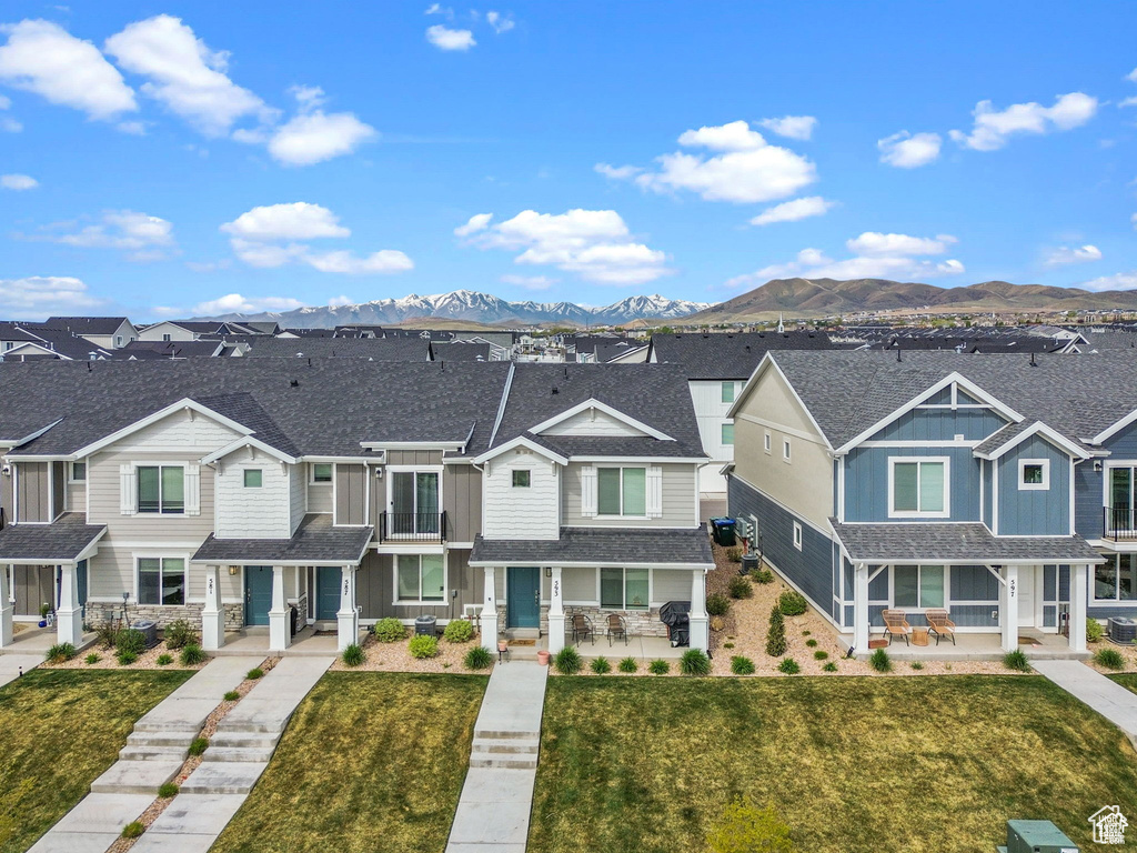 Townhome / multi-family property featuring covered porch, a residential view, and board and batten siding