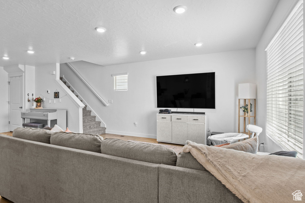 Living area featuring wood finished floors, stairway, and recessed lighting