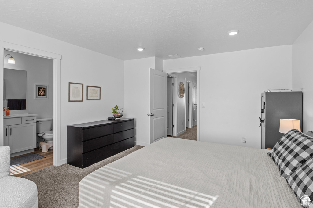 Bedroom featuring carpet floors, recessed lighting, and connected bathroom