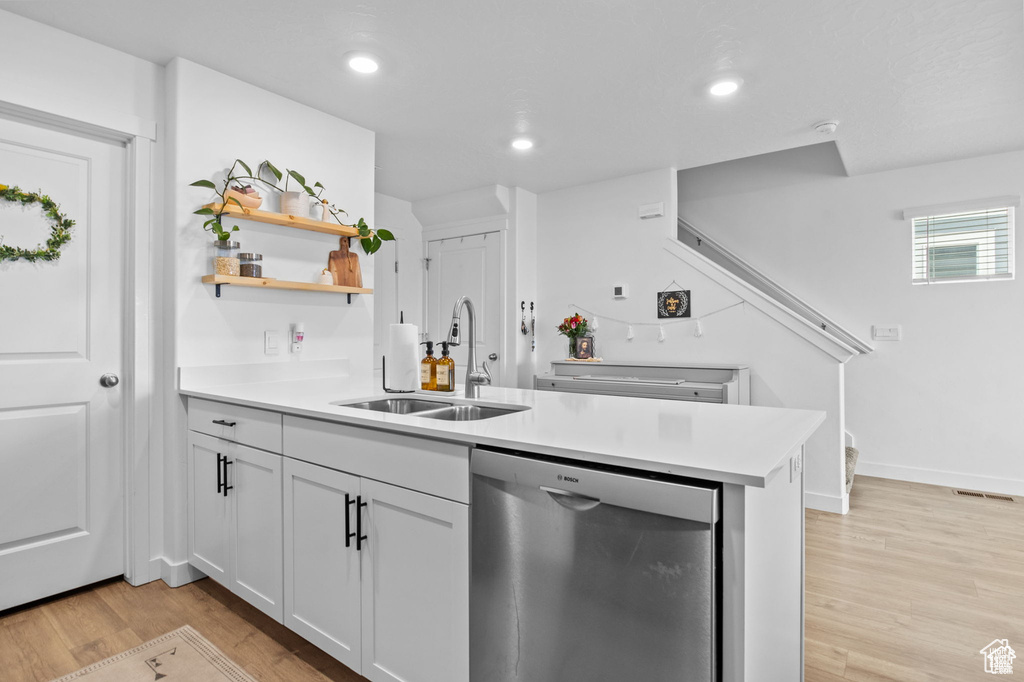 Kitchen featuring dishwasher, light wood-style flooring, a peninsula, light countertops, and recessed lighting