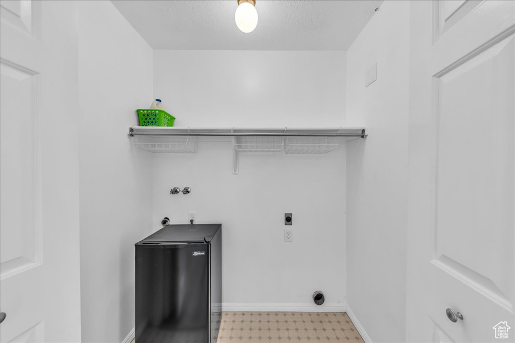 Laundry area featuring electric dryer hookup, light floors, and washer hookup