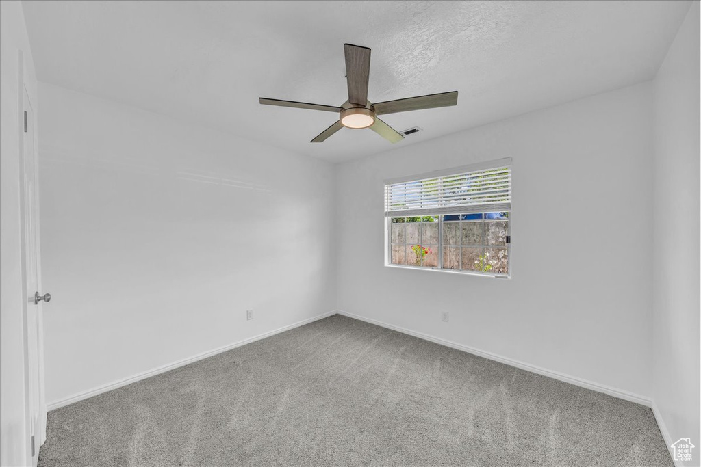 Unfurnished room featuring carpet flooring and ceiling fan