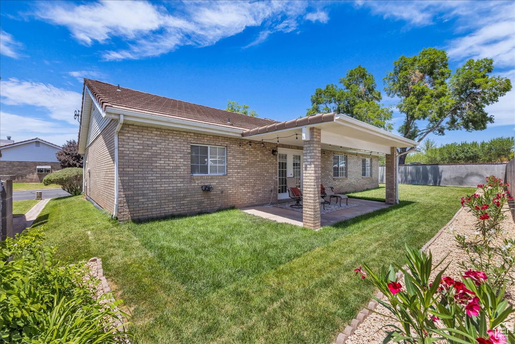 Rear view of property with brick siding, a patio area, and french doors