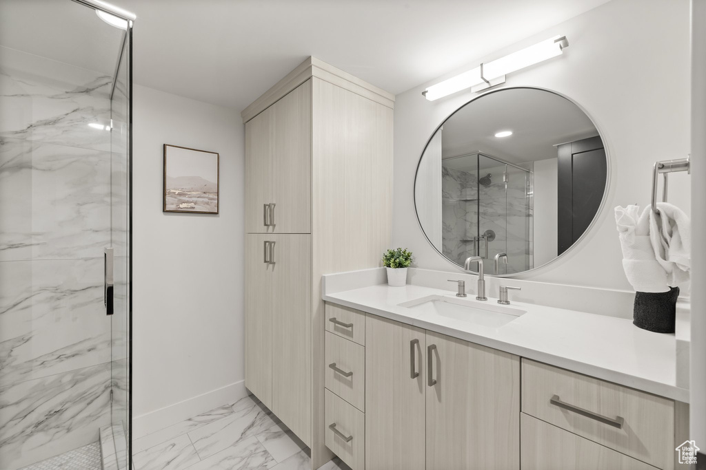 Full bathroom with a marble finish shower, marble look tile flooring, and vanity
