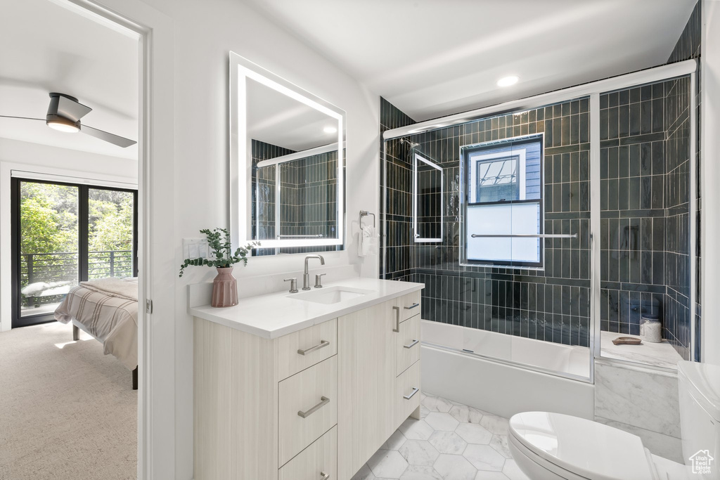 Ensuite bathroom featuring vanity, healthy amount of natural light, enclosed tub / shower combo, tile patterned flooring, and recessed lighting