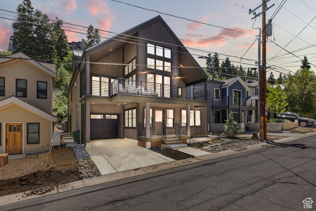 Contemporary house with a balcony, a garage, and driveway
