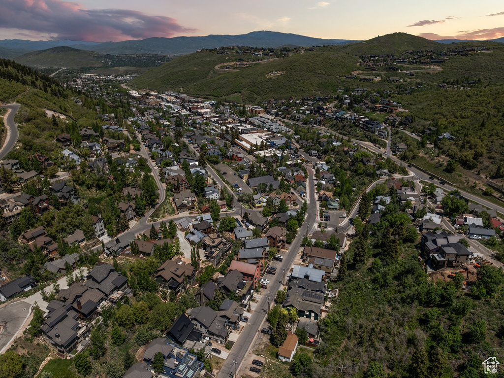 Aerial view of property and surrounding area featuring a mountain backdrop and nearby suburban area