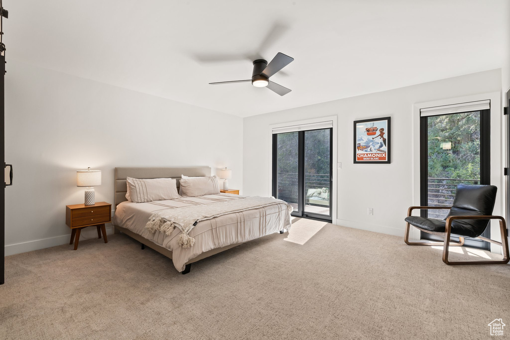Bedroom with access to exterior, multiple windows, light carpet, and a ceiling fan