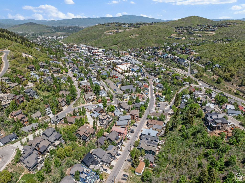 Aerial view of property's location featuring a mountainous background and nearby suburban area