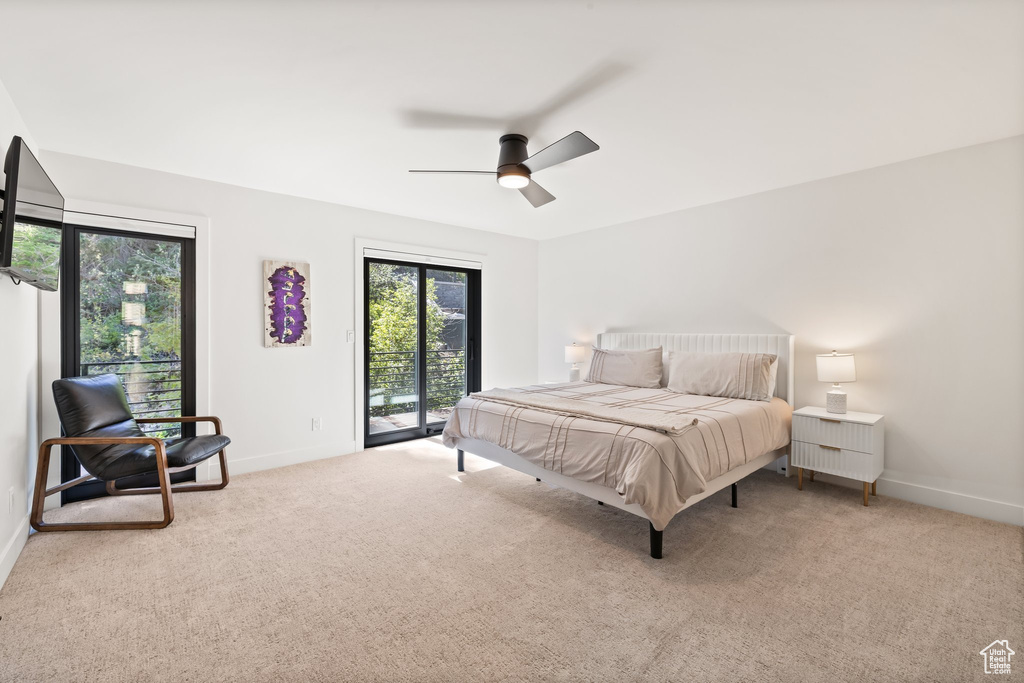 Carpeted bedroom featuring access to exterior, multiple windows, and ceiling fan