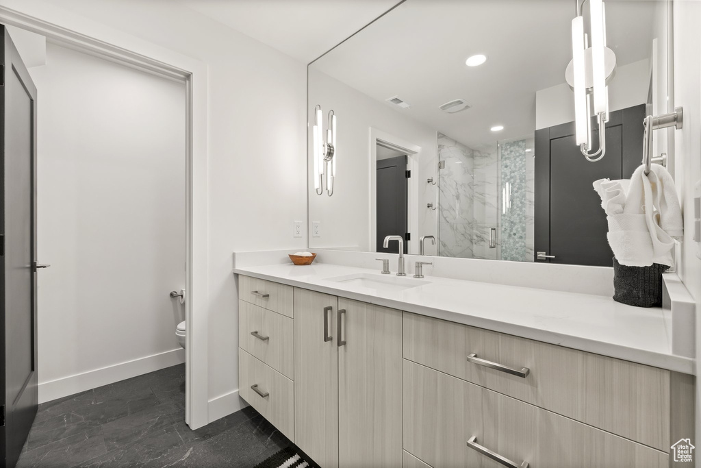 Full bath featuring vanity, a marble finish shower, and recessed lighting