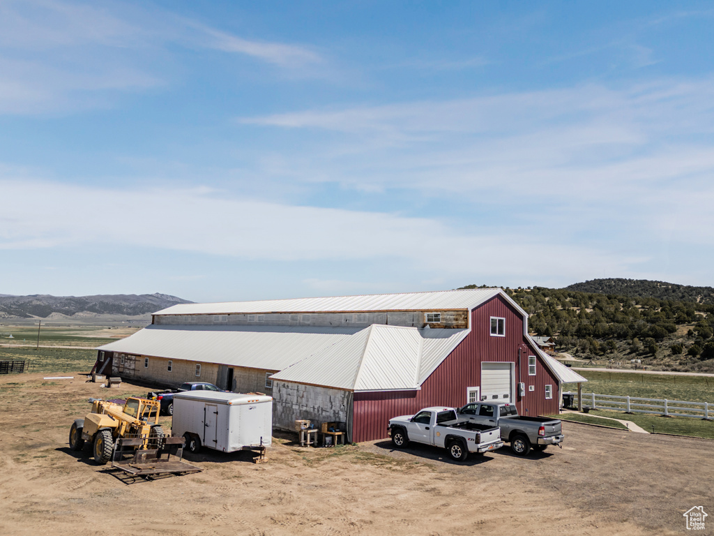 View of pole building with a rural view and asphalt driveway