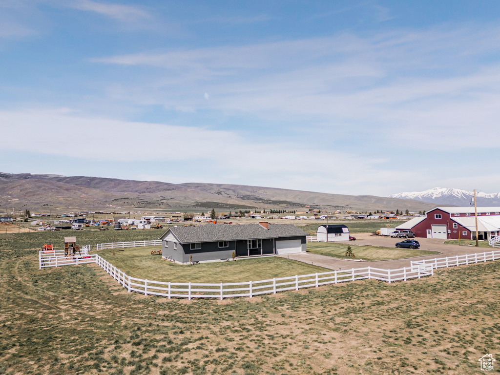 Fenced yard featuring a mountain view, a view of rural / pastoral area, and an outbuilding