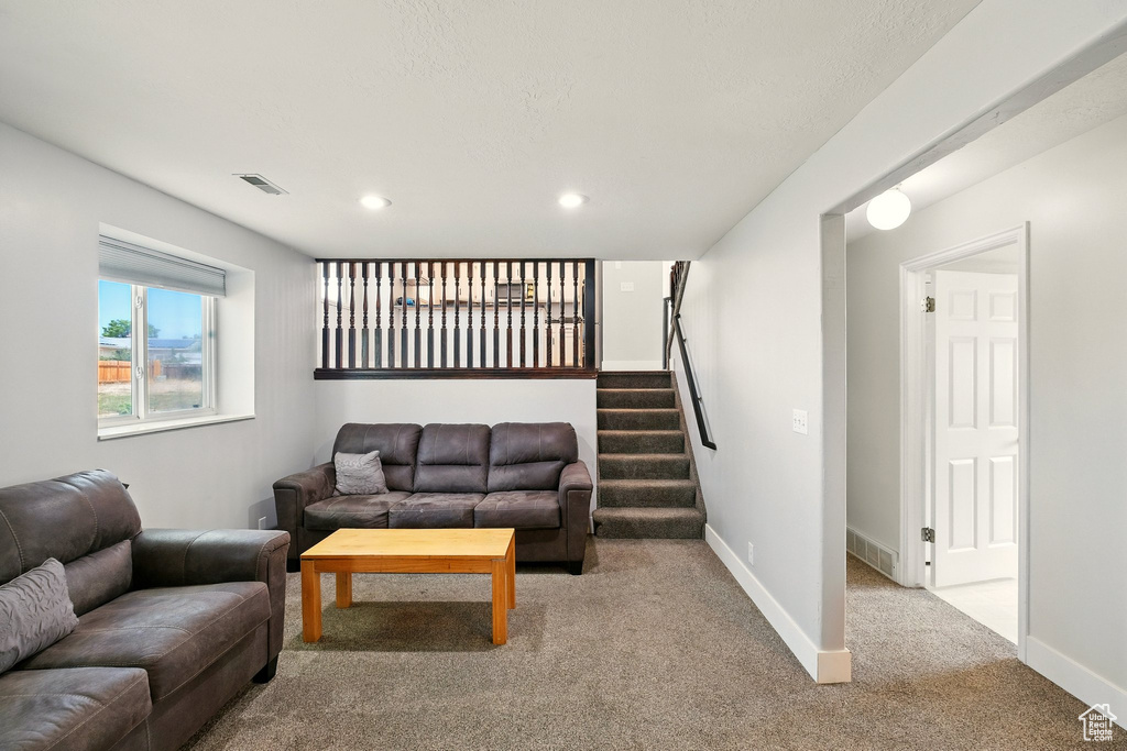 Living room with carpet floors, stairway, and recessed lighting