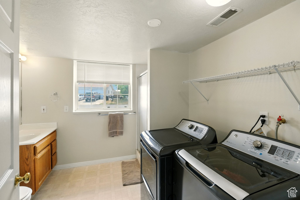 Laundry room with washing machine and clothes dryer and light flooring