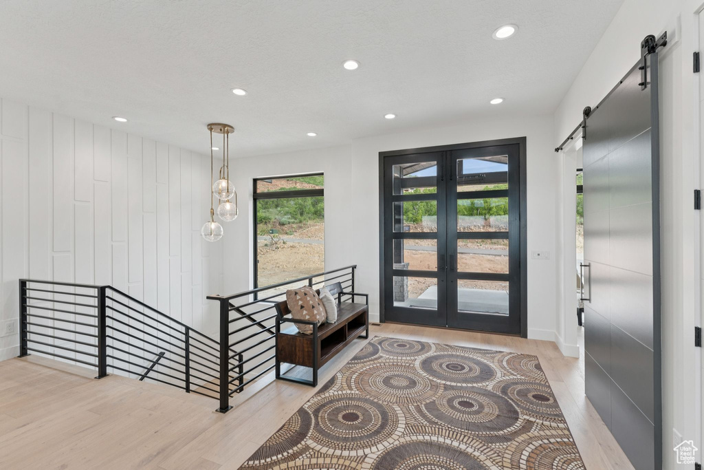 Entryway featuring a barn door, wood finished floors, french doors, and recessed lighting