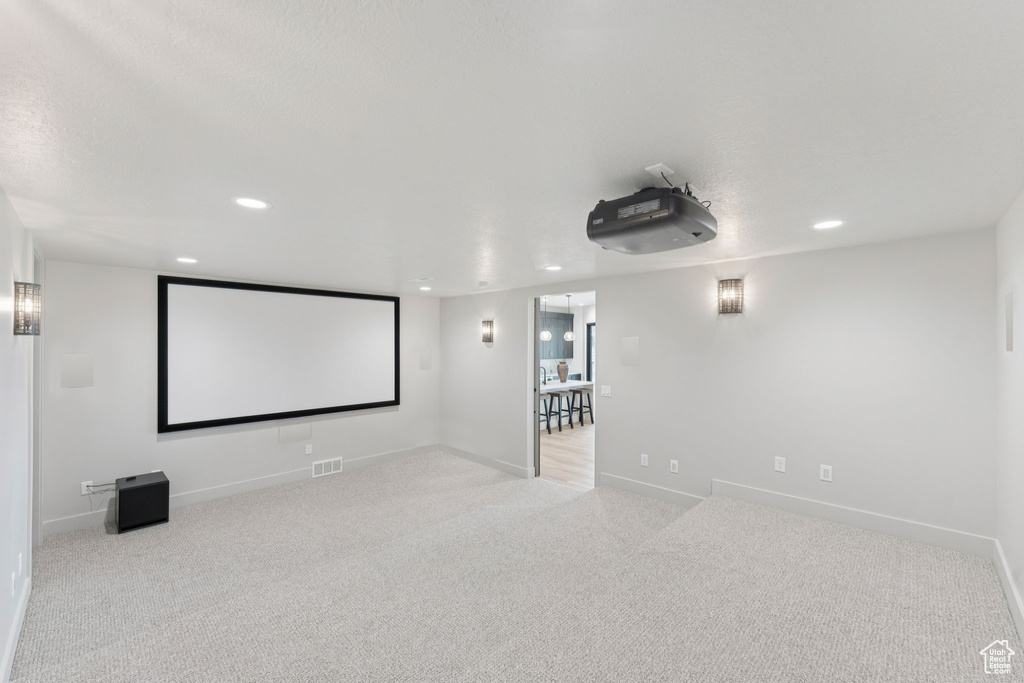 Home theater room with recessed lighting and carpet floors