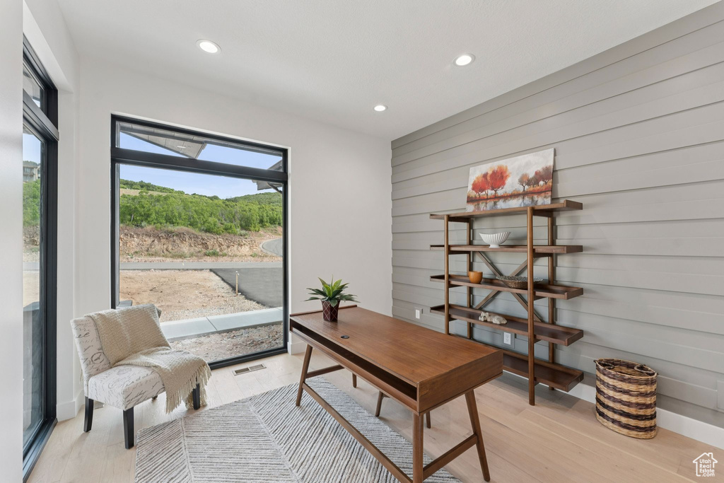 Office area featuring recessed lighting, light wood-style floors, and wooden walls