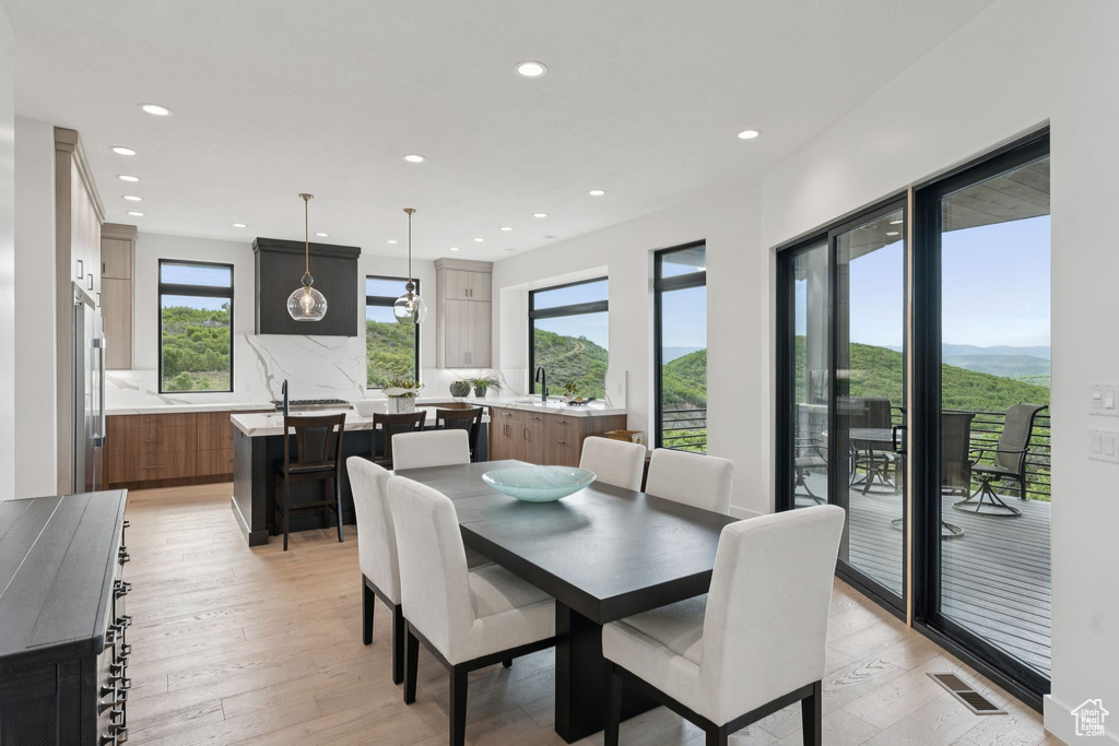 Dining space featuring healthy amount of natural light, recessed lighting, and light wood-style floors