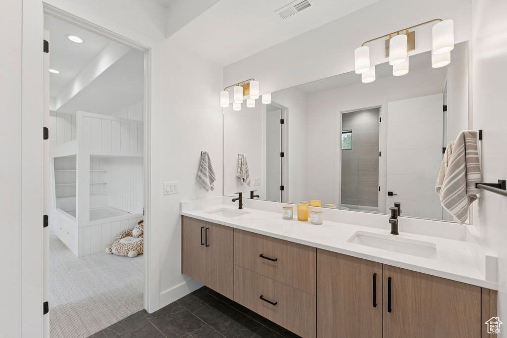 Bathroom featuring double vanity and tiled shower