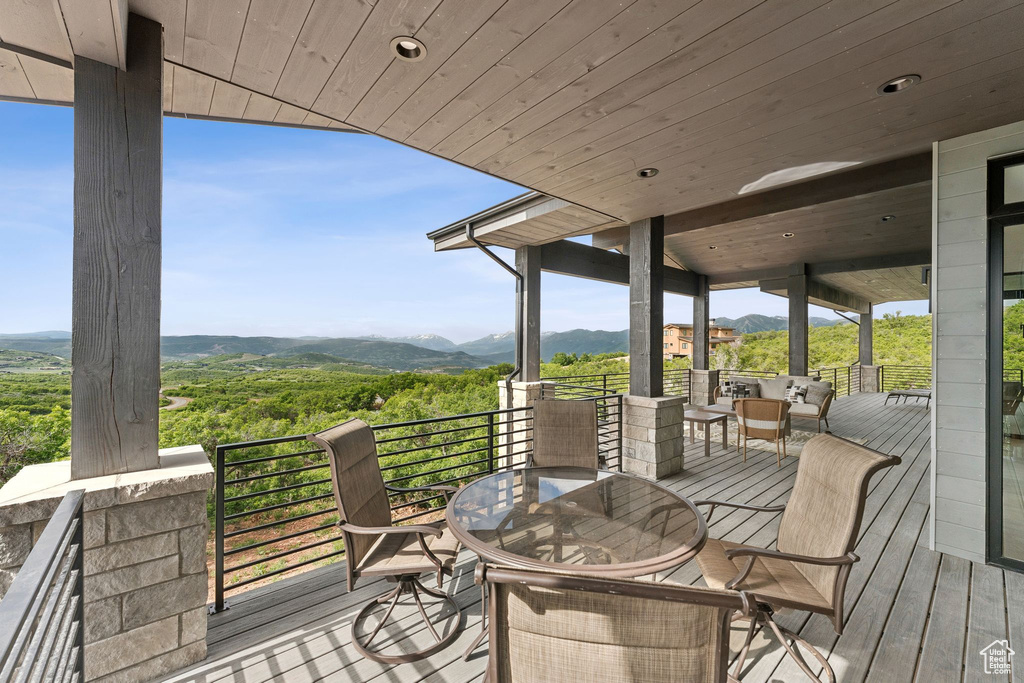 Wooden deck featuring a mountain view and outdoor dining area