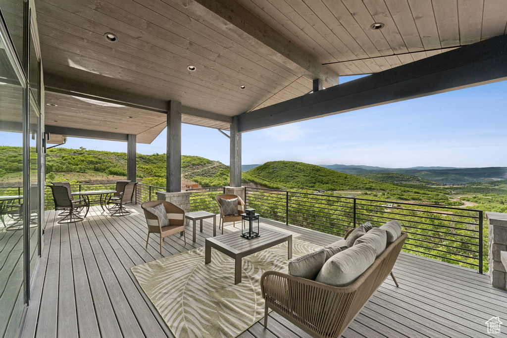 Wooden terrace with an outdoor living space, a mountain view, and outdoor dining space