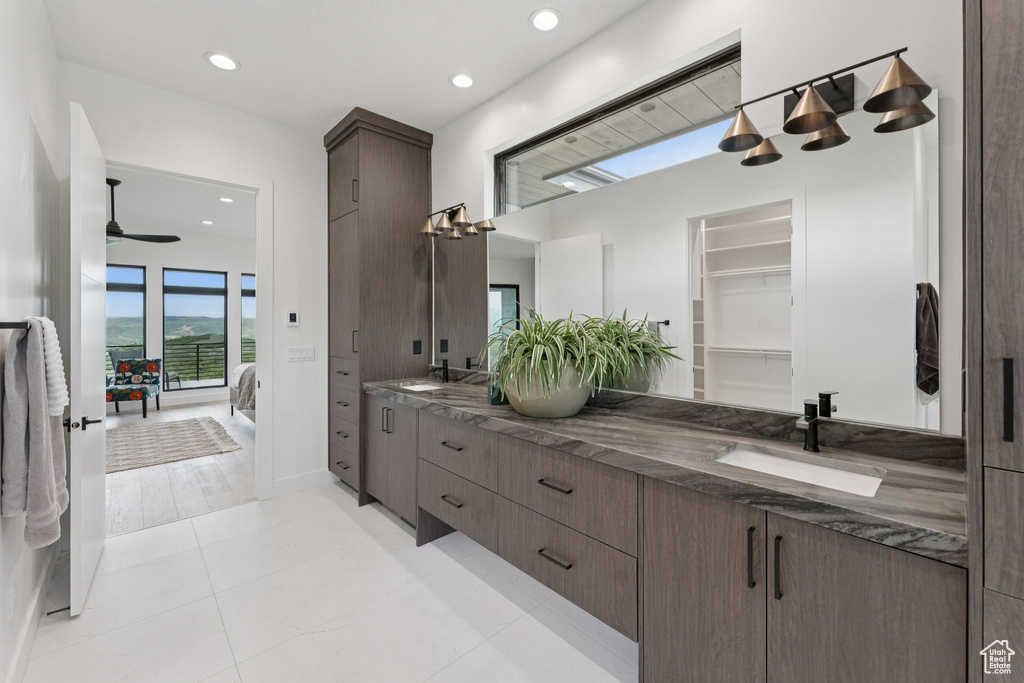 Ensuite bathroom with double vanity, ceiling fan, recessed lighting, and a closet