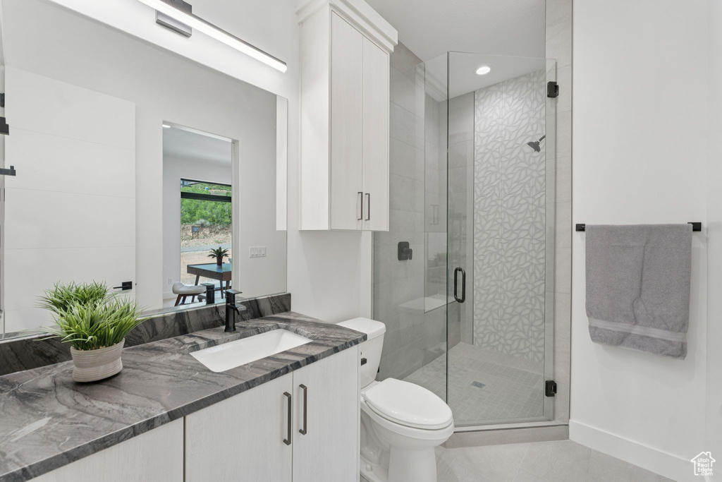 Bathroom featuring vanity, tile patterned flooring, a shower stall, and recessed lighting