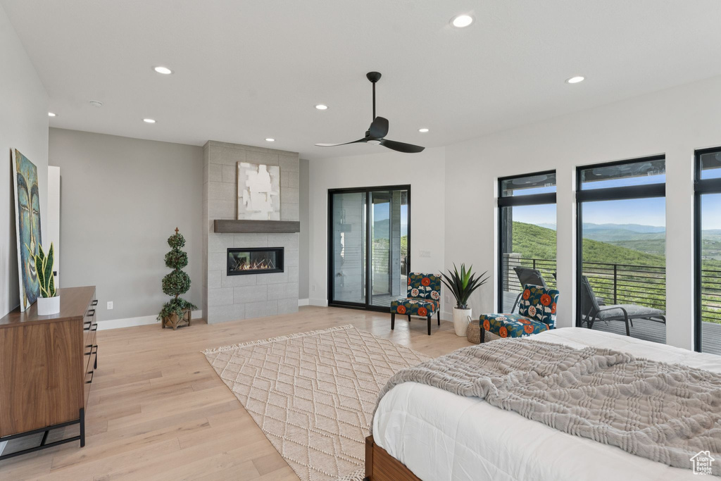 Bedroom featuring recessed lighting, light wood-style floors, access to outside, a tile fireplace, and ceiling fan