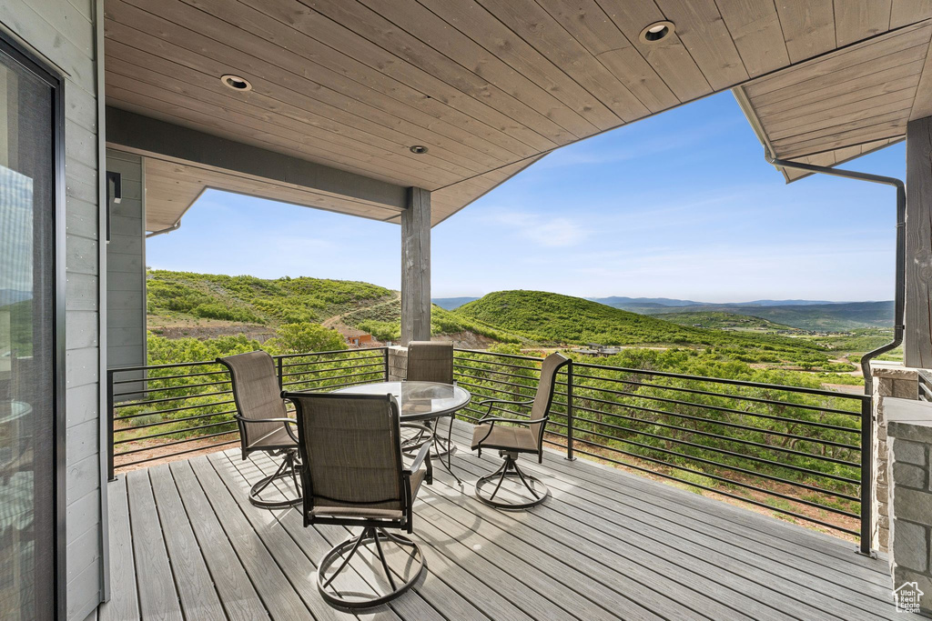 Wooden deck featuring outdoor dining space and a mountain view