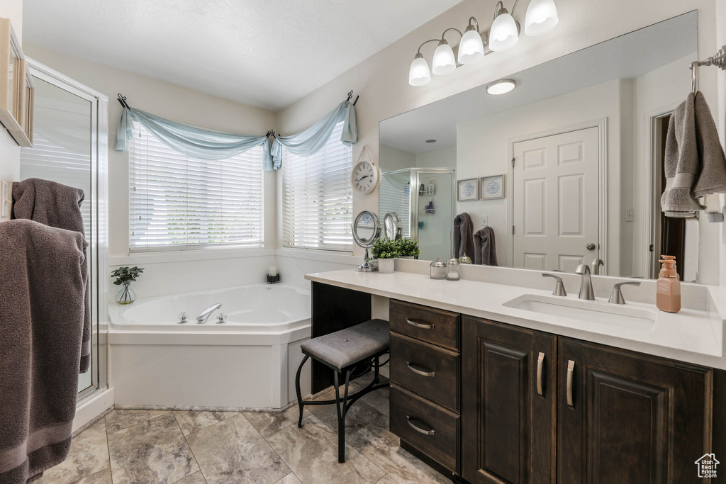 Full bathroom with vanity, a bath, and a shower stall