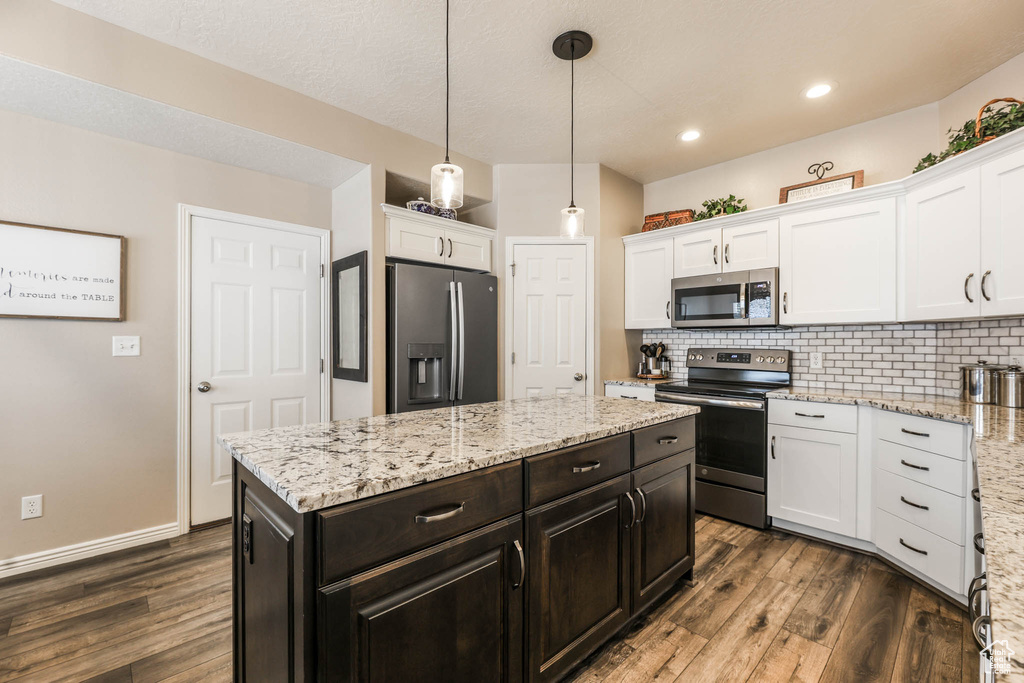 Kitchen featuring appliances with stainless steel finishes, white cabinets, dark wood-type flooring, and recessed lighting