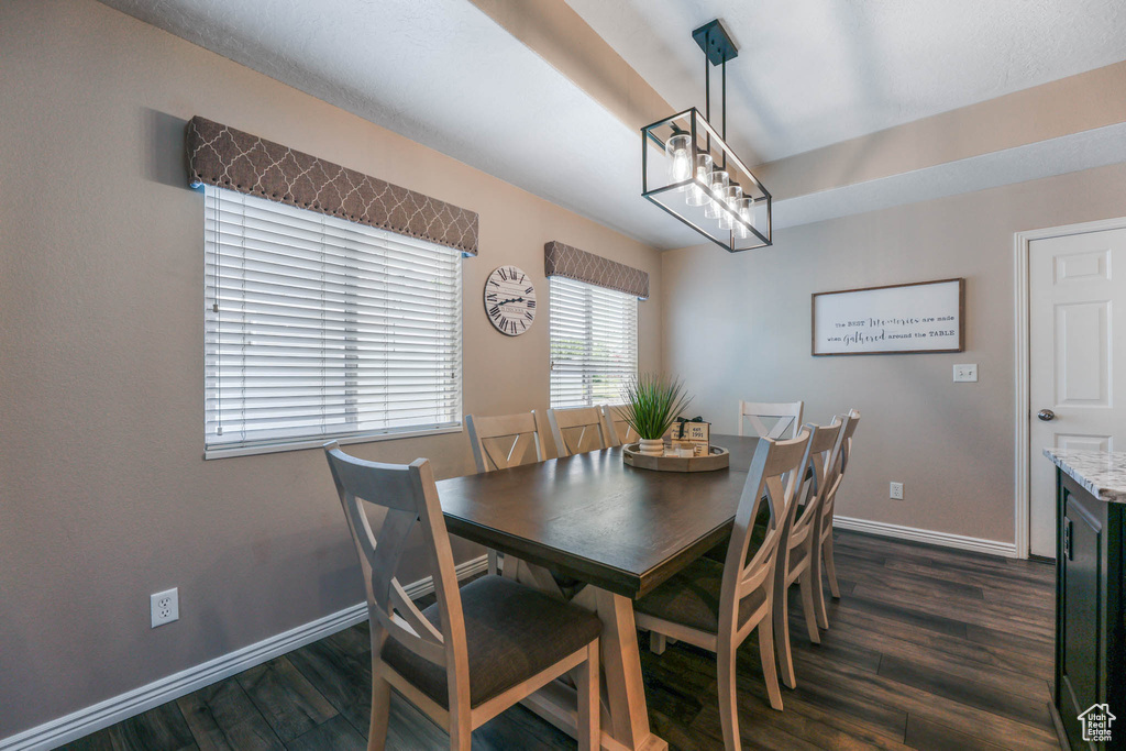 Dining space featuring dark wood-style flooring and a chandelier