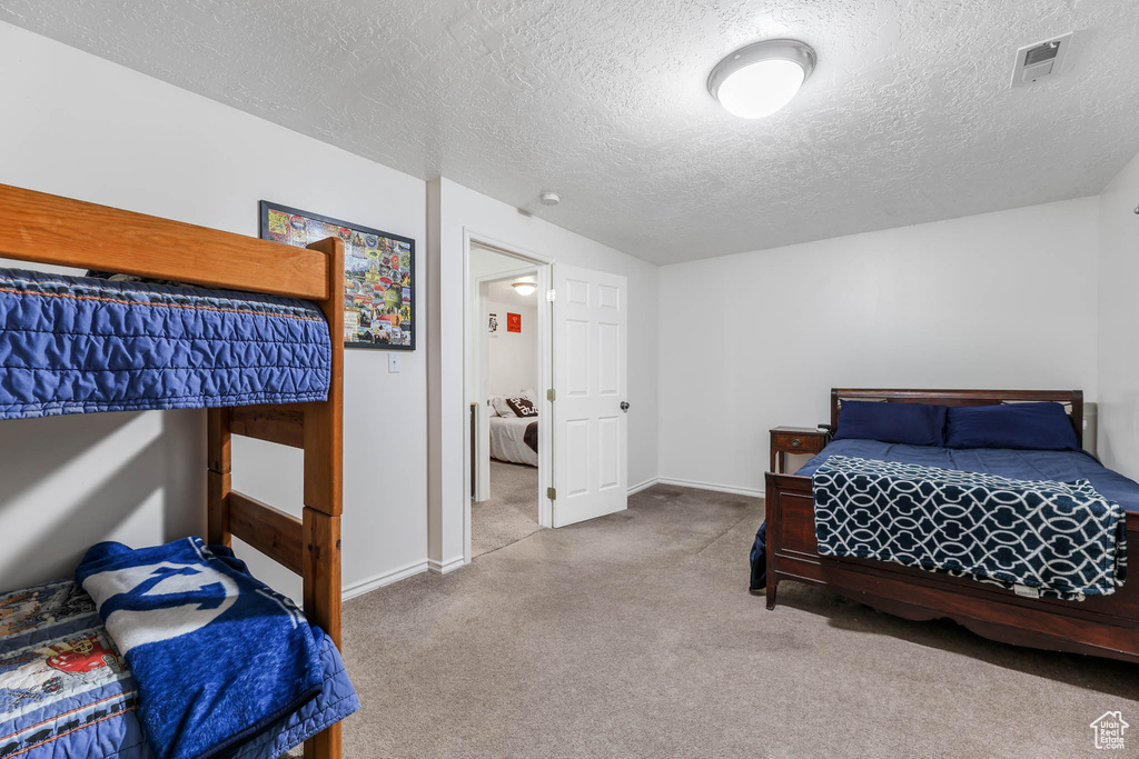 Carpeted bedroom featuring a textured ceiling